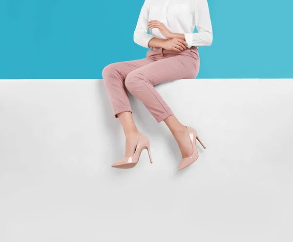 Frau trägt stilvolle Schuhe auf farbigem Hintergrund, Nahaufnahme — Stockfoto