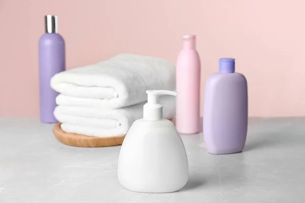 Toalhas e produtos de higiene pessoal frescos na mesa de mármore cinza claro — Fotografia de Stock