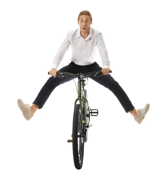 Захоплений молодий чоловік їде на велосипеді на білому тлі — стокове фото