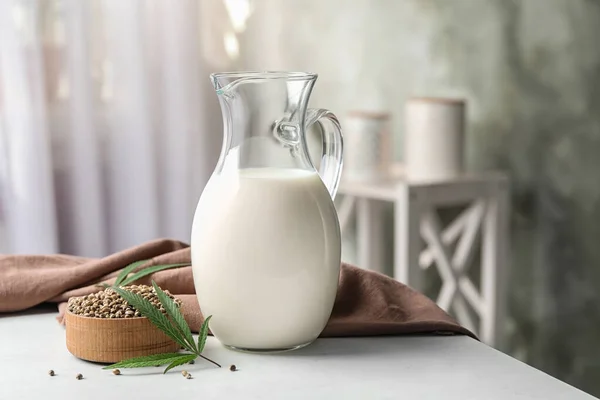 Composition with hemp milk on white table indoors