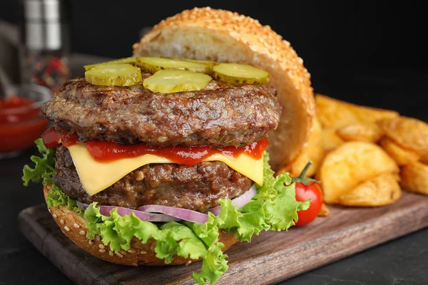 Délicieux hamburger avec escalopes de viande sur table noire, gros plan — Photo