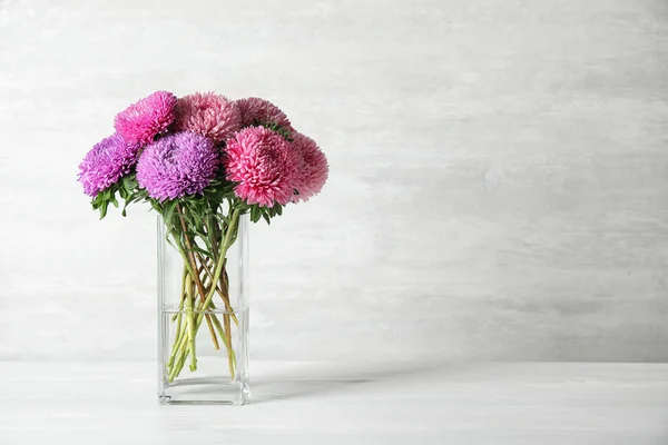 Cam vazo ve güzel paskalya çiçekleri. Masanın üzerinde, arka planda. Metin için boşluk — Stok fotoğraf