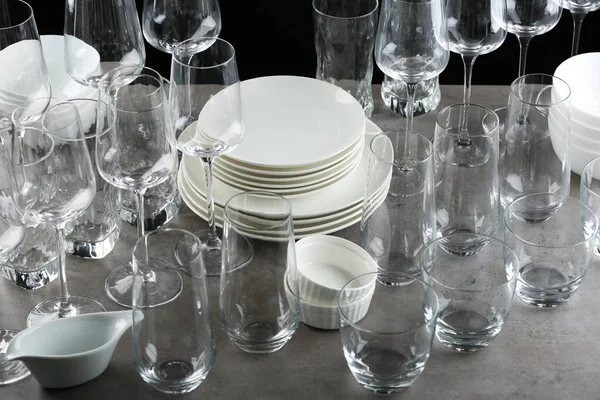 Set de vasos vacíos y vajilla sobre mesa gris — Foto de Stock