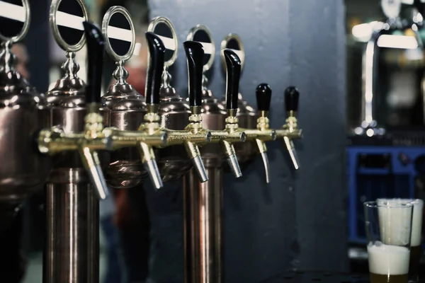 New modern beer taps on bar counter in pub — Stock Photo, Image