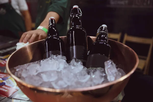 Garrafas de cerveja servidas em tigela de metal com gelo na mesa — Fotografia de Stock