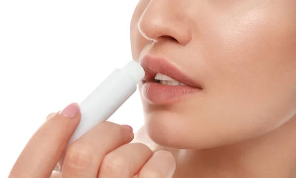 Νεαρή γυναίκα με κρύο πληγή εφαρμογή lip balm σε λευκό φόντο, closeup — Φωτογραφία Αρχείου