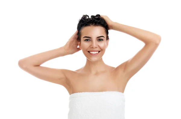 Hermosa joven lavando el cabello sobre fondo blanco — Foto de Stock
