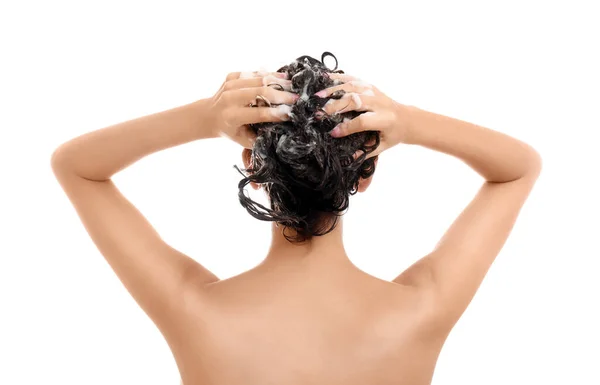 Ung kvinna tvätta håret på vit bakgrund — Stockfoto