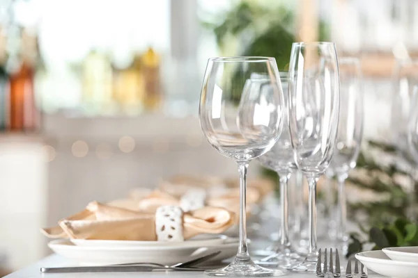Ajuste de mesa con vasos, platos y cubiertos vacíos en interiores — Foto de Stock