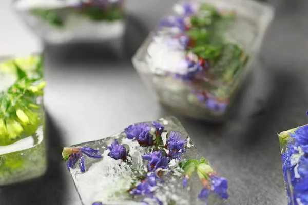 Glaçons avec des fleurs sur table en pierre grise, gros plan — Photo