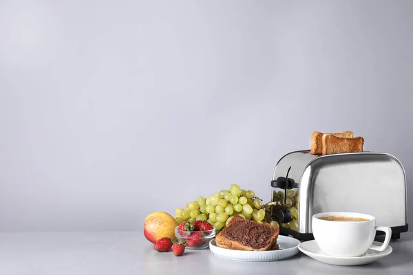Здоровий сніданок і сучасний тостер на світло-сірому столі, простір для тексту — стокове фото