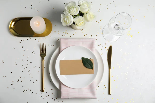 Elegante festliche Tischdekoration mit leerer Karte auf weißem Hintergrund, flach gelegt — Stockfoto
