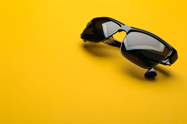 Lunettes de soleil élégantes sur fond jaune, espace pour le texte. Accessoire tendance — Photo