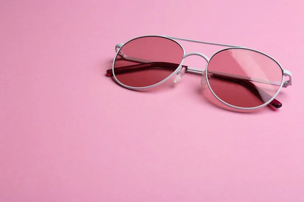 Occhiali da sole eleganti su sfondo rosa, spazio per il testo. Accessorio alla moda — Foto Stock