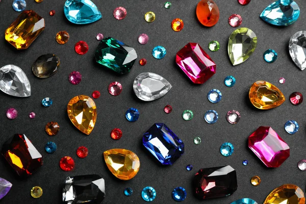 Different beautiful gemstones on black background, flat lay — Stock Photo, Image