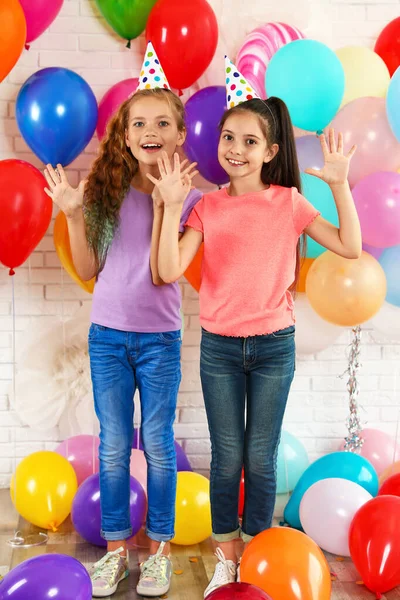 Niños felices cerca de globos brillantes en la fiesta de cumpleaños en el interior —  Fotos de Stock