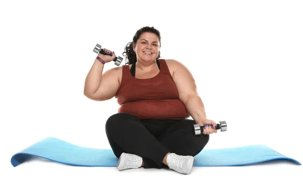 Nadváha žena s podložkou a činky na bílém pozadí — Stock fotografie