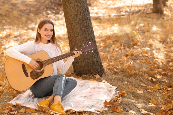 Tini lány gitározik őszi parkban — Stock Fotó