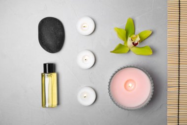 Spa taşları ve gri masada yanan mumlarla bezenmiş düz bir yapı.