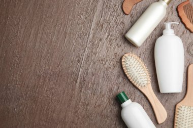 Düz kompozisyon, saç kozmetik ürünleri ve kahverengi arka planda aletler. Metin için boşluk