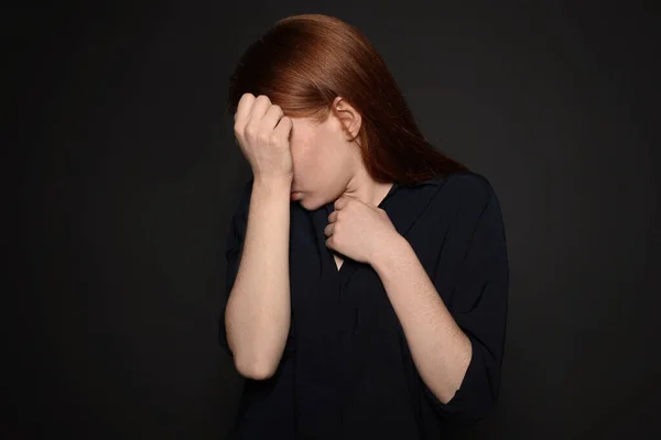 Mujer joven molesta llorando sobre fondo oscuro — Foto de Stock