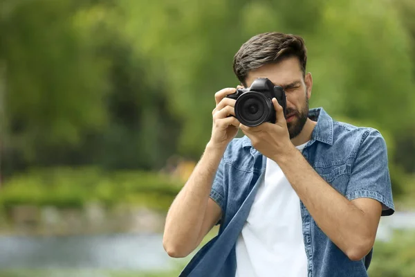Φωτογράφος λήψη φωτογραφιών με επαγγελματική κάμερα στο πάρκο — Φωτογραφία Αρχείου
