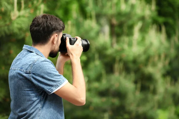 Photographe prenant des photos avec un appareil photo professionnel dans le parc. Espace pour le texte — Photo