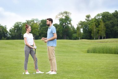 Koç kadınlara yeşil sahada golf oynamayı öğretiyor.