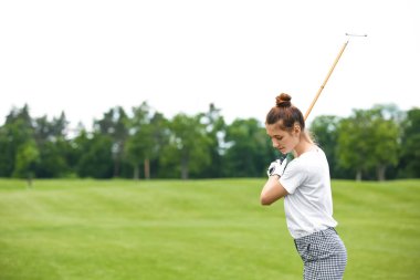 Yeşil sahada golf oynayan kadın. Spor ve eğlence