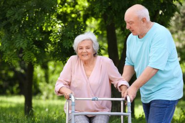 Yaşlı adam çerçeve açık havada yürüyüş ile eşi yardım