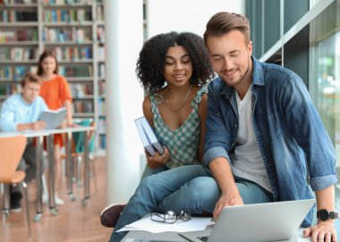 Gençler modern kütüphanede birlikte okuyorlar.