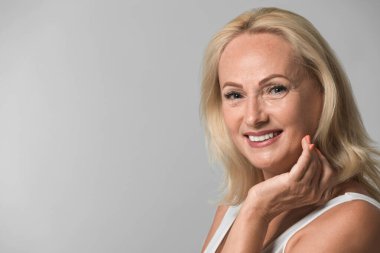 Gri arka plan üzerinde mükemmel bir cilt ile güzel olgun kadın Portresi. Metin için alan