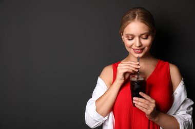 Siyah arka planda kola bardağı olan genç bir kadın, metin için yer. Ferahlatıcı içecek