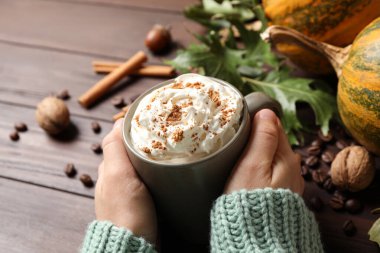 Ahşap masada bir fincan lezzetli balkabağı aromalı latte, yakın plan.