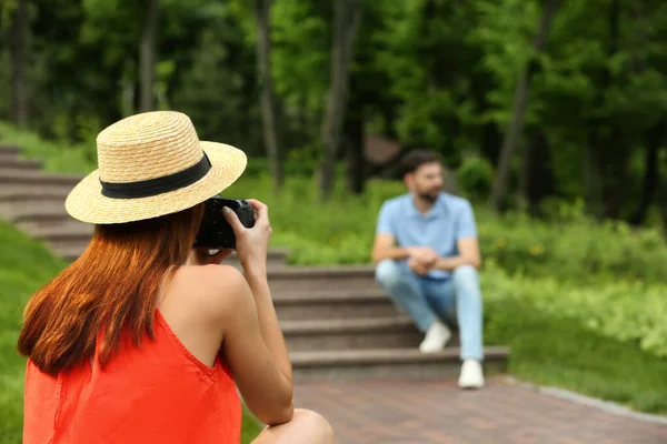 Fotograf robi zdjęcia człowiekowi z profesjonalnym aparatem w parku — Zdjęcie stockowe