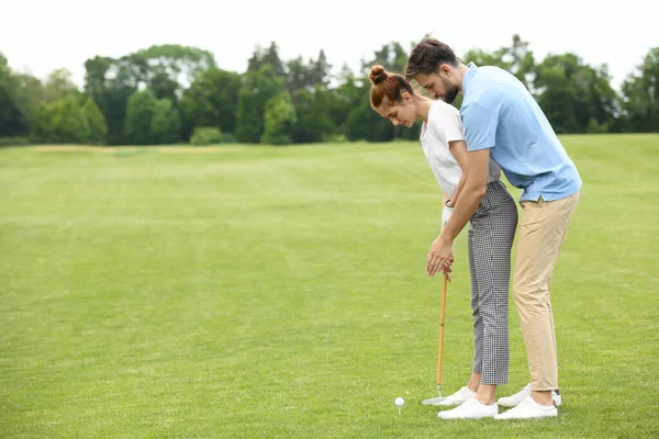 Treinador mulher de ensino para jogar golfe no campo verde — Fotografia de Stock