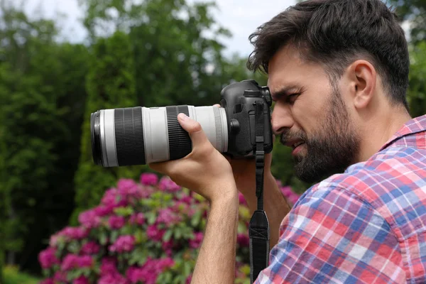 Photographe prenant des photos avec appareil photo professionnel dans le parc — Photo