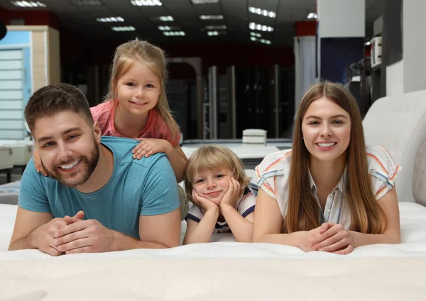 Glückliche Familie liegt auf neuer orthopädischer Matratze im Geschäft — Stockfoto