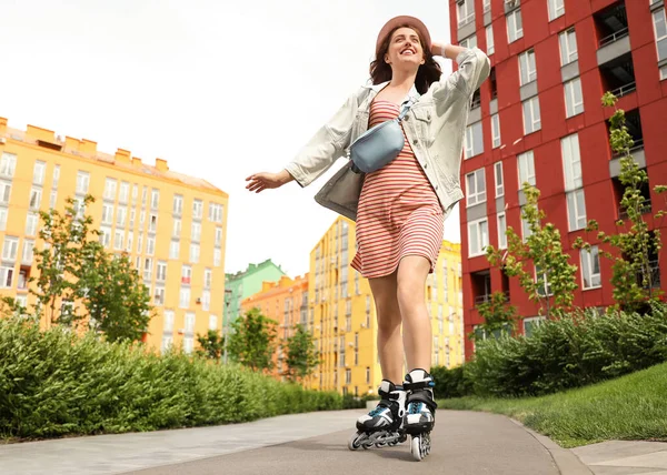 Hermosa mujer joven con patines que se divierten al aire libre, espacio para el texto —  Fotos de Stock