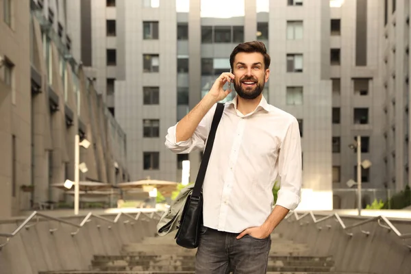 Bonito homem falando ao telefone na cidade moderna — Fotografia de Stock