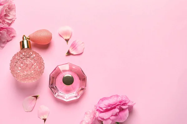 Плоская композиция с духами бутылки и цветы на светло-розовом фоне, пространство для текста — стоковое фото