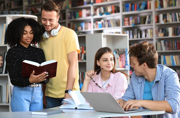 Grupo de jovens que estudam à mesa na biblioteca — Fotografia de Stock