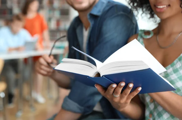 Giovani che studiano insieme nella biblioteca moderna, primo piano — Foto Stock