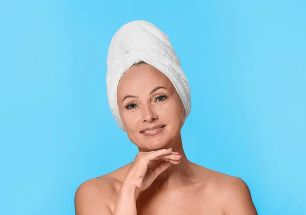 Portret van mooie rijpe vrouw met perfecte huid op licht blauwe achtergrond — Stockfoto