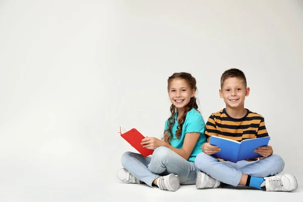Małe dzieci czytające książki na szarym tle. Miejsce na tekst — Zdjęcie stockowe