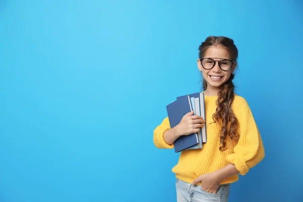 Χαριτωμένο κοριτσάκι με γυαλιά και βιβλία σε μπλε φόντο, χώρος για κείμενο. Έννοια ανάγνωσης — Φωτογραφία Αρχείου