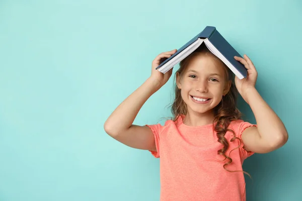 Retrato de linda chica con libro sobre fondo turquesa, espacio para el texto. Concepto de lectura — Foto de Stock