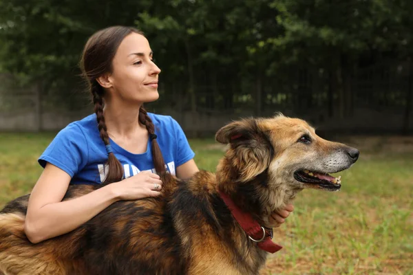 Mujer voluntaria con perro sin hogar en refugio de animales al aire libre — Foto de Stock