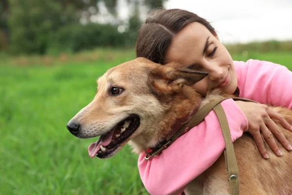 Female volunteer with homeless dog at animal shelter outdoors — Stock Photo, Image