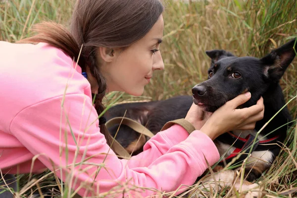 Mujer voluntaria con perro sin hogar en refugio de animales al aire libre — Foto de Stock